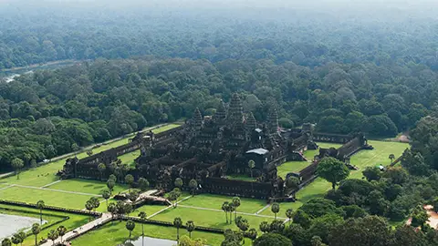 Vue aérienne d’un vaste complexe de temples au milieu d’une forêt dense.