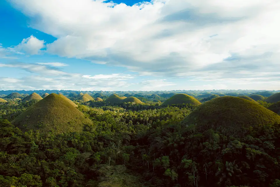 Chocolate Hills à Bohol, aux Philippines, avec collines verdoyantes couvertes de végétation tropicale.