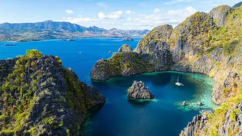 Point de vue sur une lagune turquoise entourée de falaises
