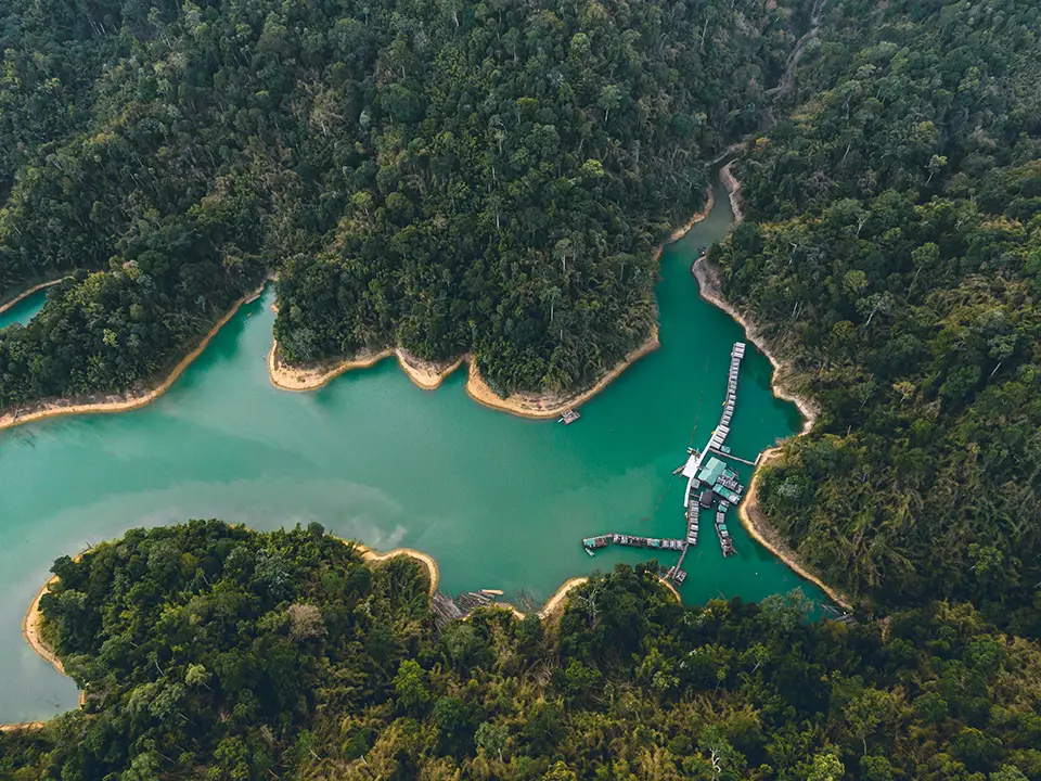 Vue aérienne du lac de Khao Sok, entouré de jungle, en Thaïlande.