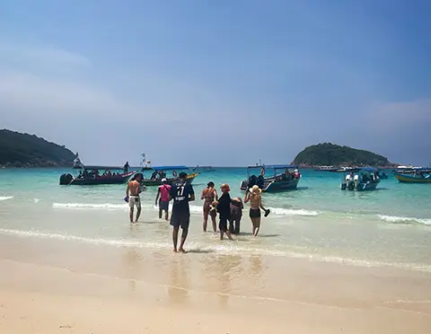 Groupe de personnes marchant sur une plage de sable blanc