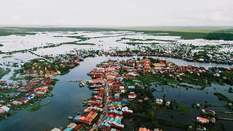 Vue aérienne d’un village flottant avec maisons et canaux sur l’eau.