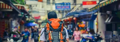 Voyageur avec sac à dos dans une rue asiatique animée